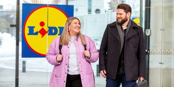 Nainen ja mies astuvat Lidl Housen ovista sisään