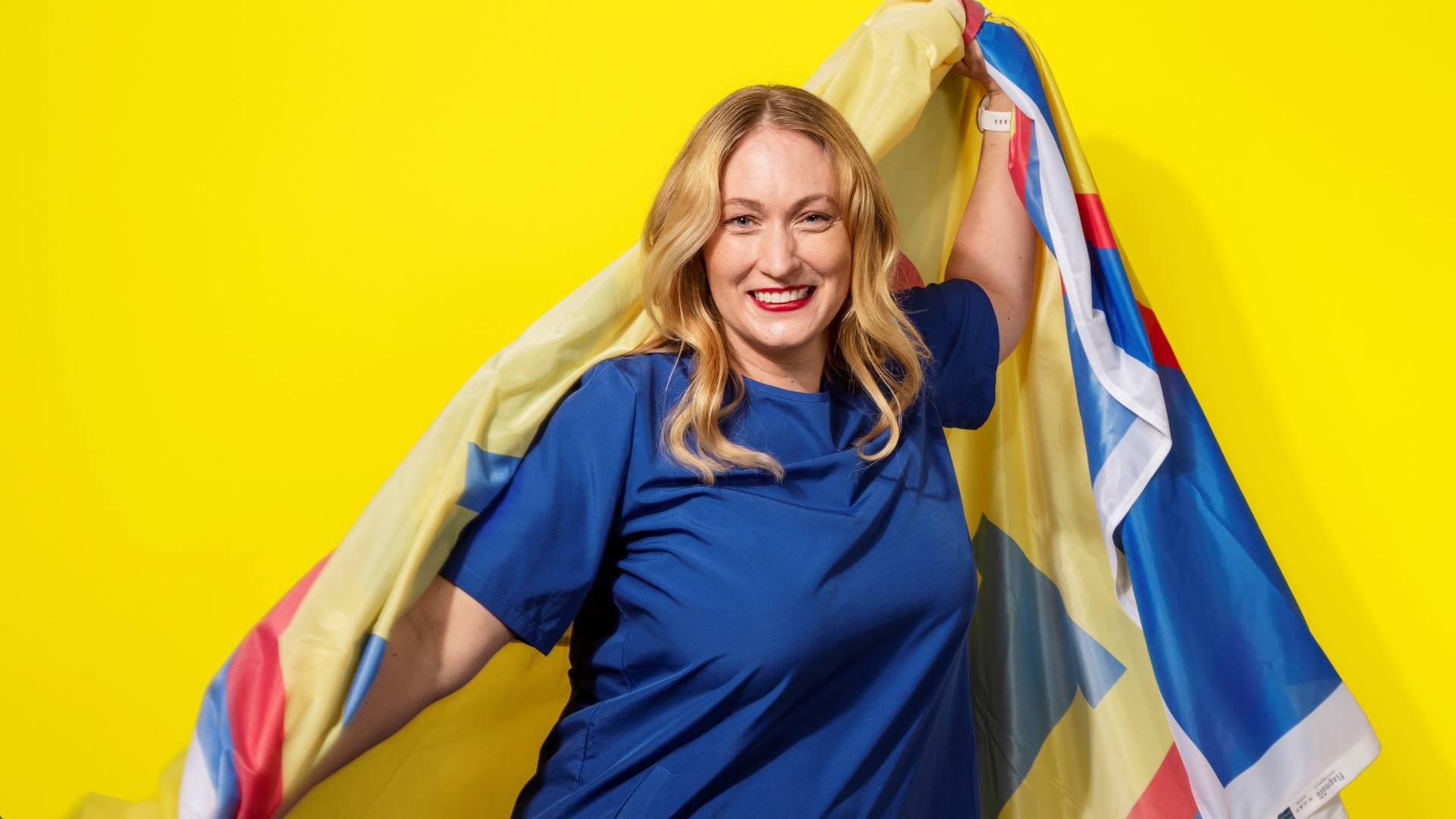 Nainen hymyilee Lidl-viitta harteillaan