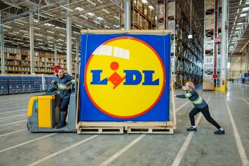 Varastotyöntekijät kuljettavat Lidlin kylttiä