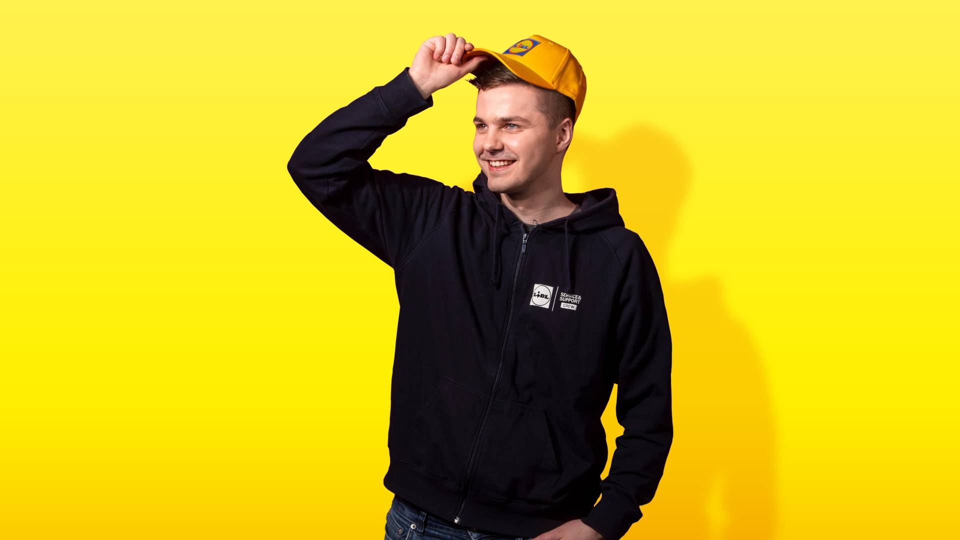 IT-työntekijä hymyilee lippis päässä.